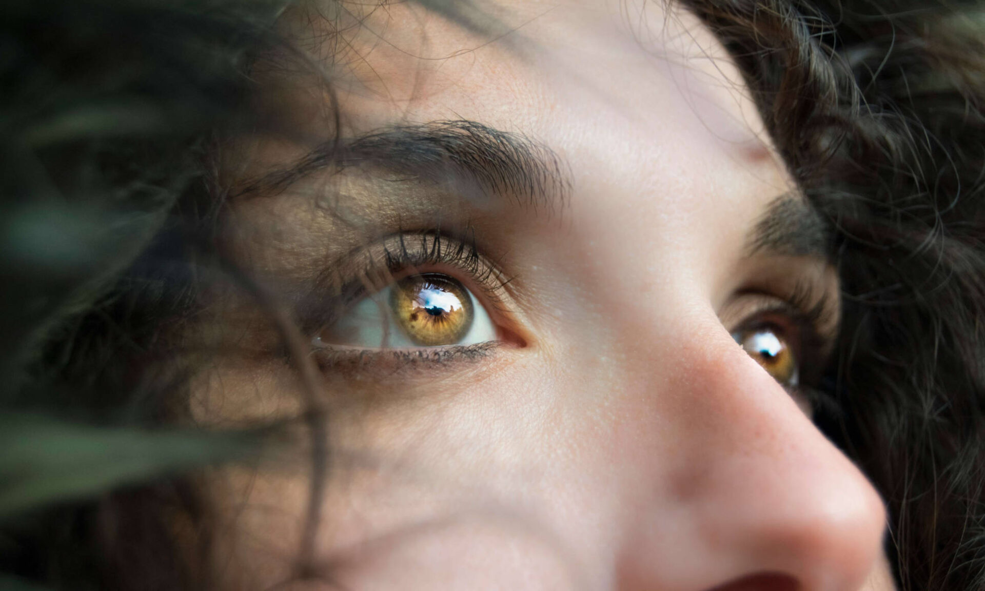 Close up of a woman's eyes and mid-face looking off camera to illustrate why eye blinking is important in humans